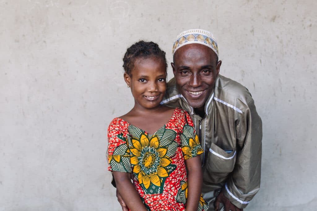 Houssainatou et son père après l'opération de sa tumeur au visage sur l'Africa Mercy, plus heureux que jamais